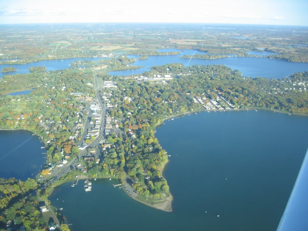 Aerial view of Lindstrom on the Chisago Lakes, with wooded shoreline and peninsulas between open water.